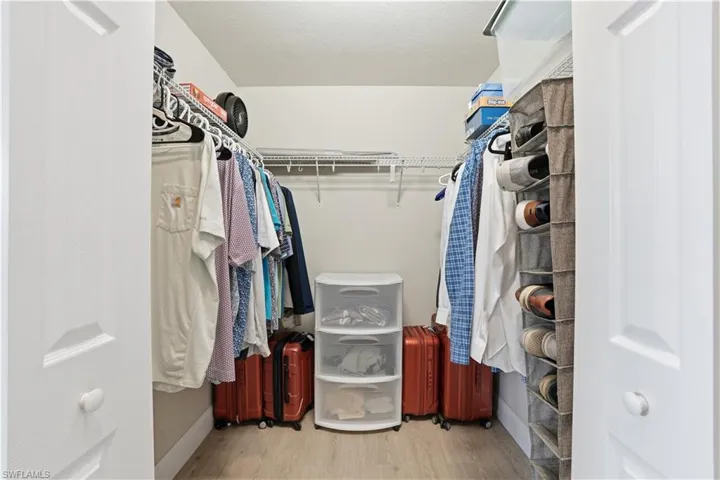 Walk in closet with light wood-type flooring