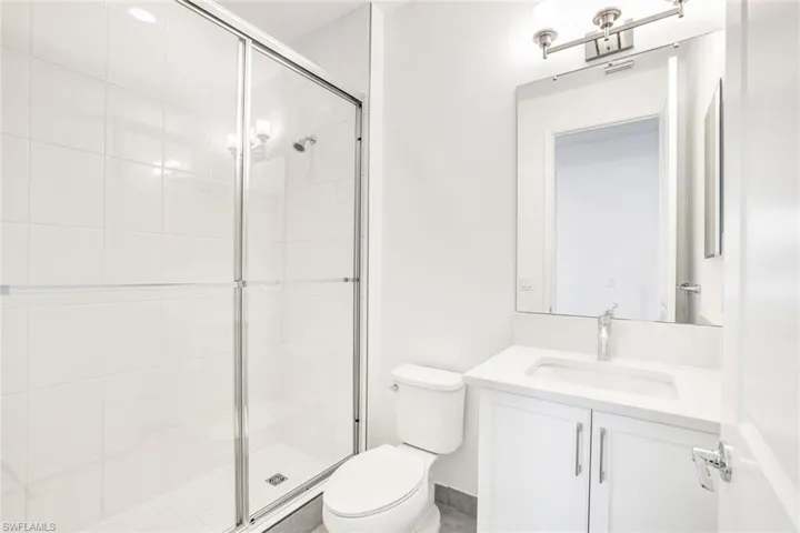 Bathroom with an enclosed shower, toilet, and vanity