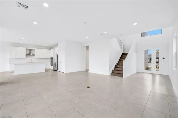 Unfurnished living room with light tile patterned flooring and sink