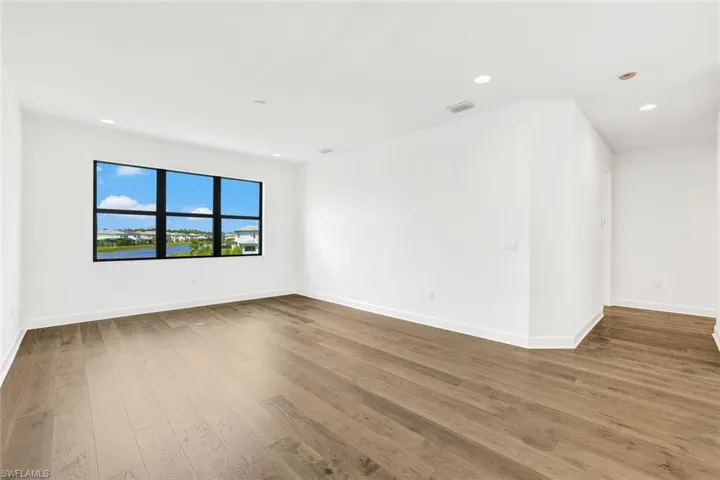 Unfurnished room with lofted ceiling and wood-type flooring