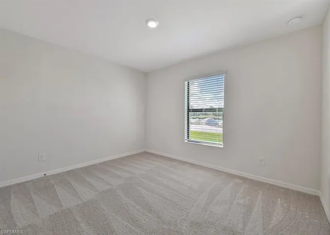Unfurnished room with carpet and a smoke detector