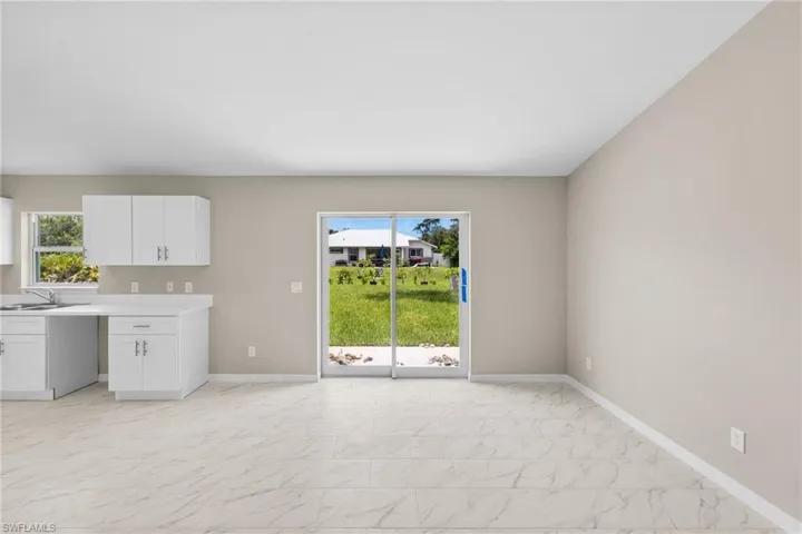 Kitchen with light marble finish flooring, white cabinets, and light countertops