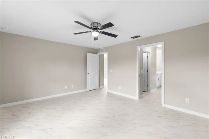 Unfurnished bedroom with light marble finish flooring and ceiling fan
