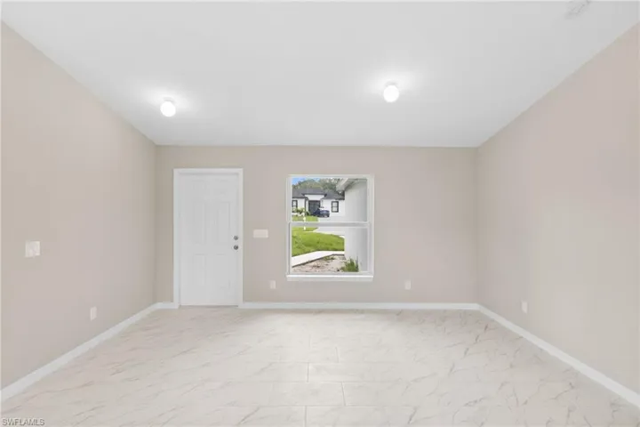 Spare room with light marble finish flooring and baseboards