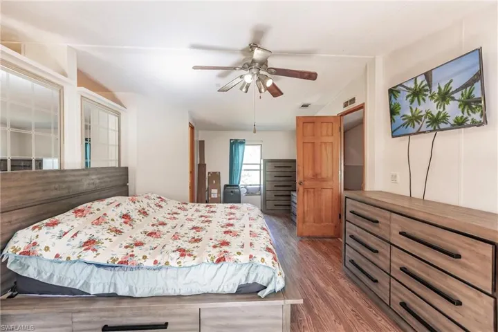 Bedroom with ceiling fan and dark hardwood / wood-style floors