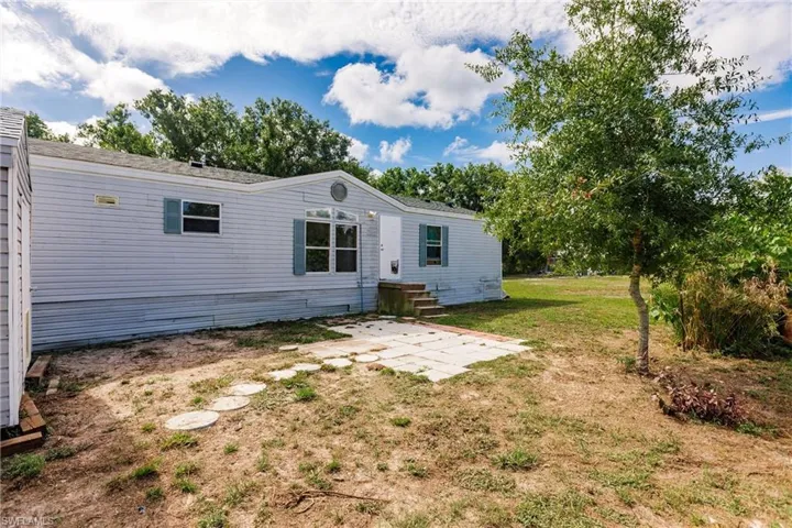 Back of property with a patio area and a lawn