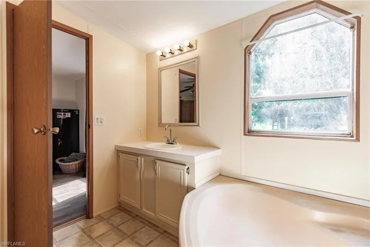Bathroom with vanity, a bathing tub, and tile patterned floors