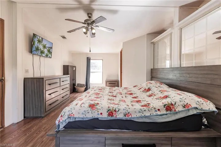 Bedroom with vaulted ceiling, ceiling fan, and dark hardwood / wood-style floors