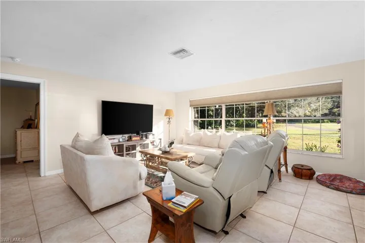 Tiled living room featuring a healthy amount of sunlight