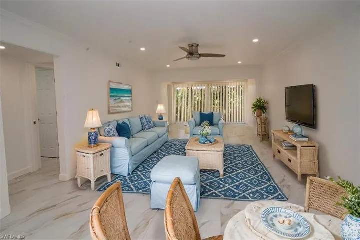Living room featuring recessed lighting, ceiling fan, marble finish floor, and ornamental molding