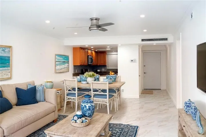 Living room with a ceiling fan, baseboards, ornamental molding, visible vents, and recessed lighting