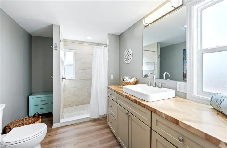 Full bathroom featuring a shower stall, vanity, toilet, and wood finished floors