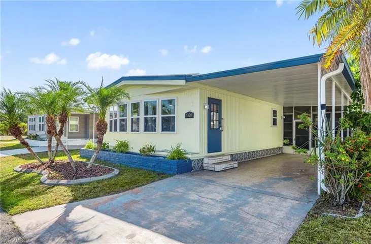 View of front of property with entry steps, concrete driveway, and a carport