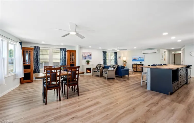 Dining space featuring a wealth of natural light, a ceiling fan, recessed lighting, and a wall mounted air conditioner