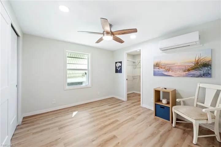 Sitting room featuring baseboards, a wall mounted air conditioner, recessed lighting, a ceiling fan, and wood finished floors