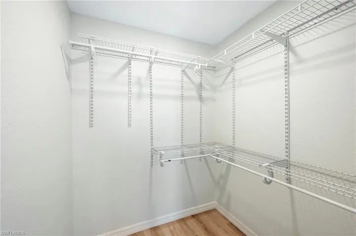 Walk in closet with light wood-style floors