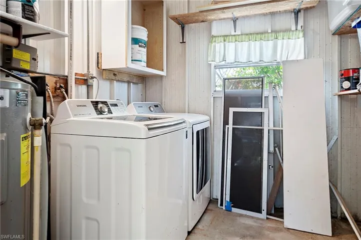 Laundry room with washer and clothes dryer, water heater, and laundry area