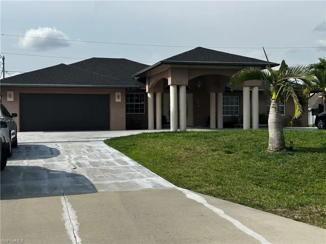 Ranch-style house with concrete driveway, an attached garage, a front yard, and stucco siding