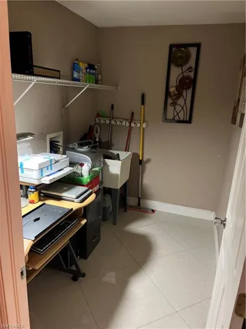 Tiled home office featuring baseboards