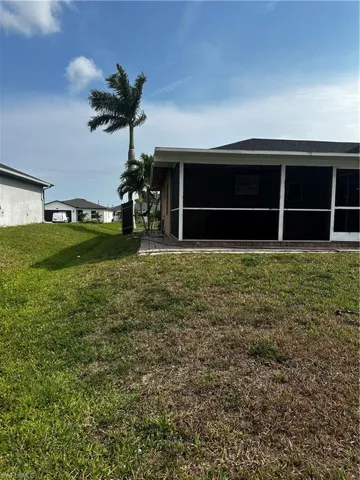 Back of house with a sunroom and a yard