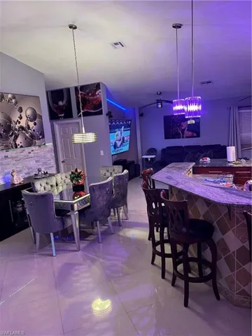 Dining space with bar and lofted ceiling