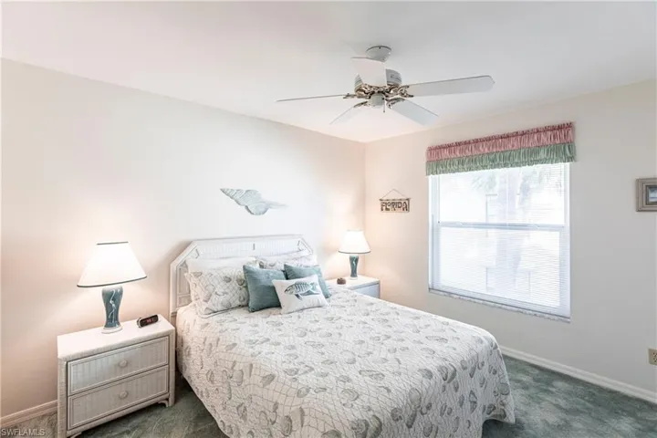 Carpeted bedroom featuring ceiling fan
