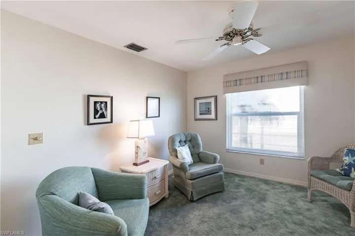 Sitting room featuring ceiling fan and carpet floors