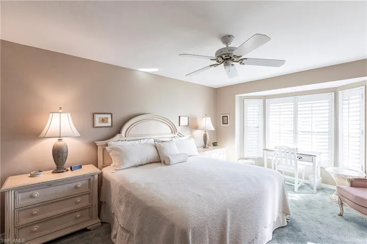Carpeted bedroom featuring ceiling fan