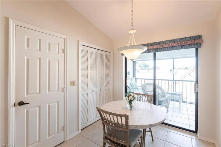 Tiled dining space featuring lofted ceiling
