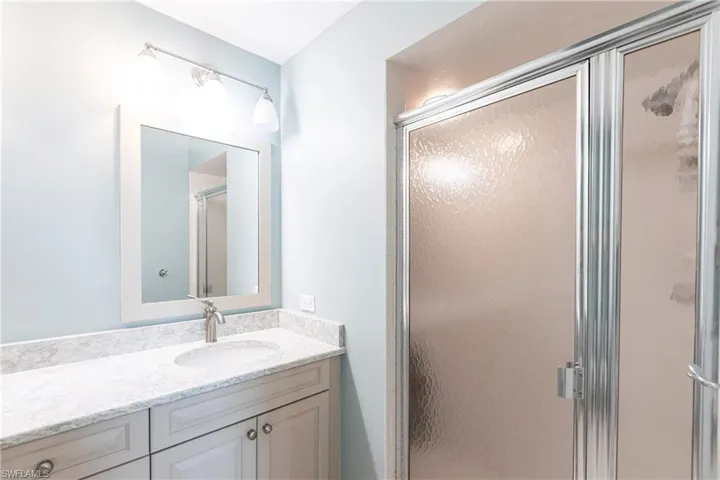 Bathroom with vanity and a shower with shower door