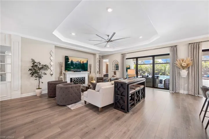 Living room featuring a tray ceiling, ceiling fan, and hardwood / wood-style floors