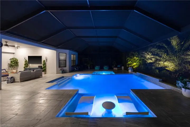 View of swimming pool featuring a patio, an outdoor living space, and an in ground hot tub