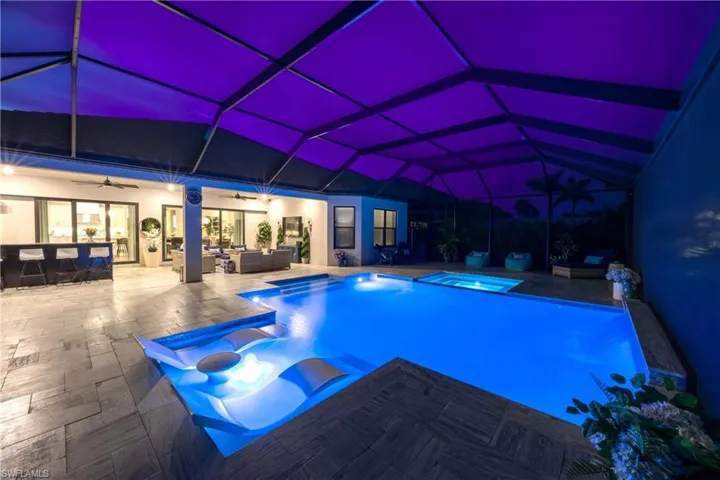 View of pool with ceiling fan, a patio, an in ground hot tub, an outdoor living space, and a lanai