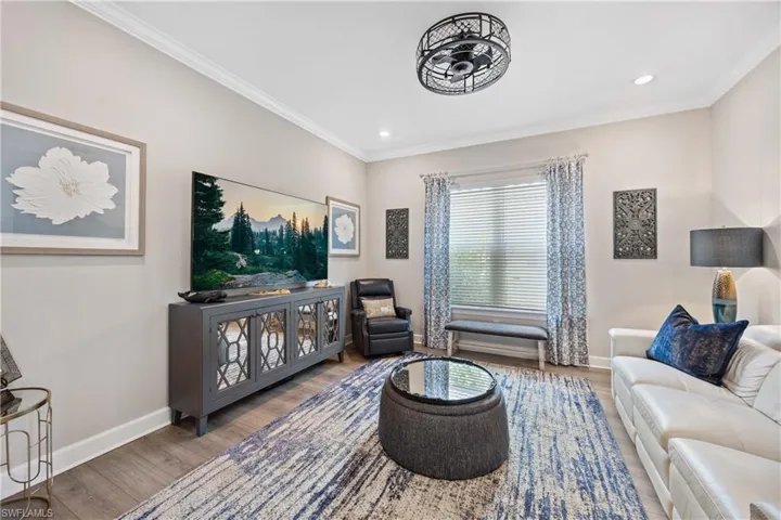 Living room with ornamental molding and wood-type flooring