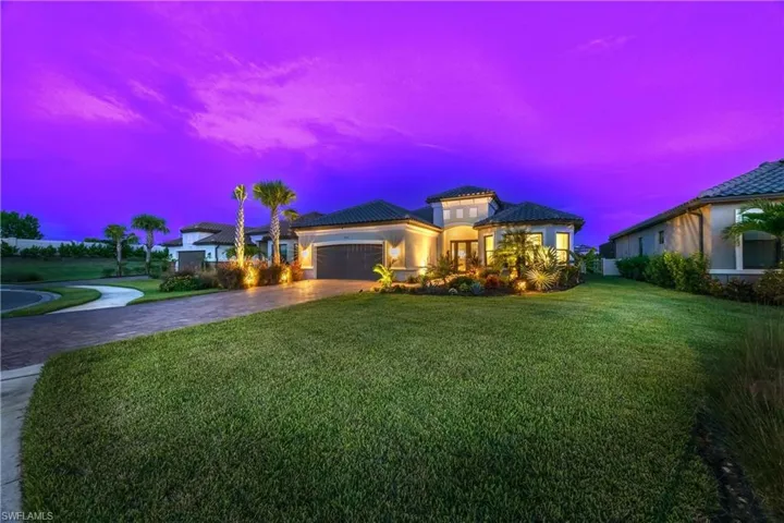 View of front of house featuring a lawn and a garage
