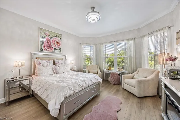Bedroom with ornamental molding, light hardwood / wood-style floors, and multiple windows