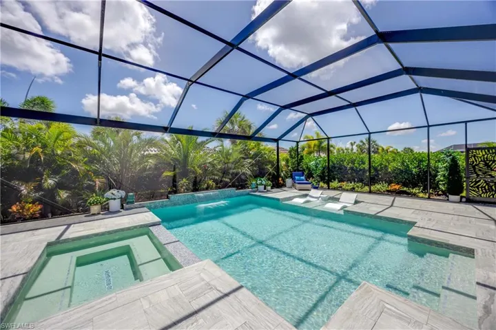 View of pool with a patio, an in ground hot tub, a lanai, and pool water feature
