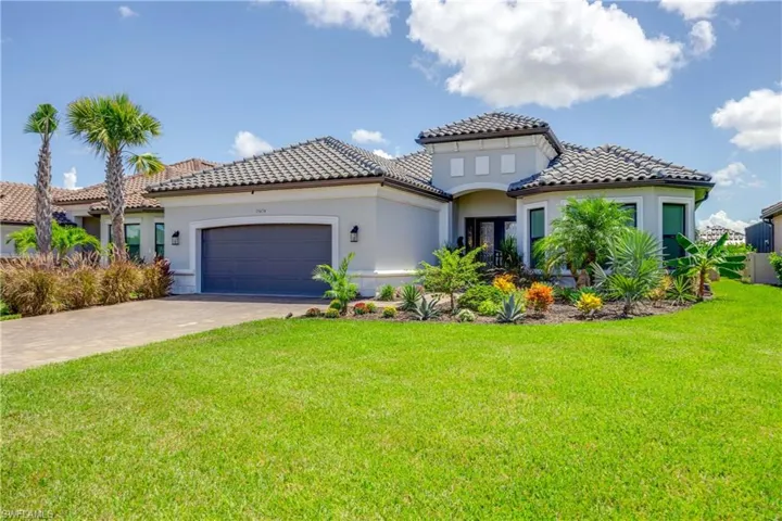 Mediterranean / spanish-style home featuring a front lawn and a garage