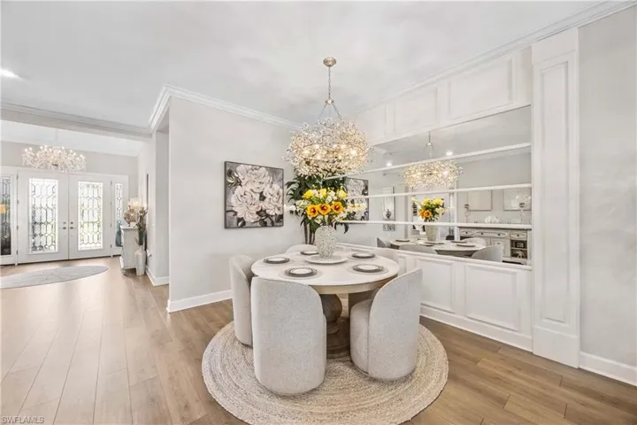 Dining space featuring ornamental molding, a chandelier, and light hardwood / wood-style floors