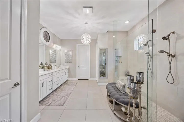 Bathroom featuring ornamental molding, tile patterned floors, walk in shower, and vanity