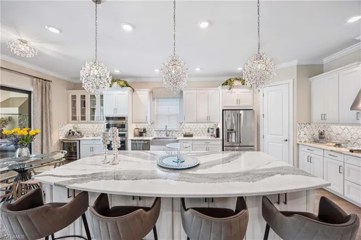 Kitchen featuring a large island, stainless steel appliances, and decorative light fixtures