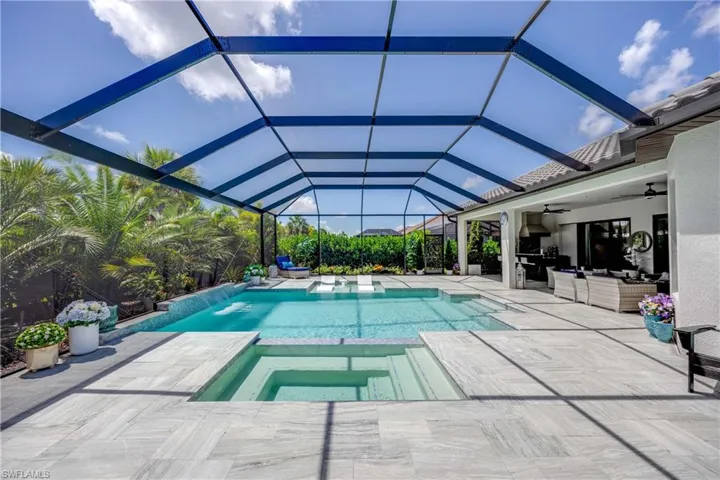 View of pool with an in ground hot tub, a lanai, ceiling fan, and a patio area