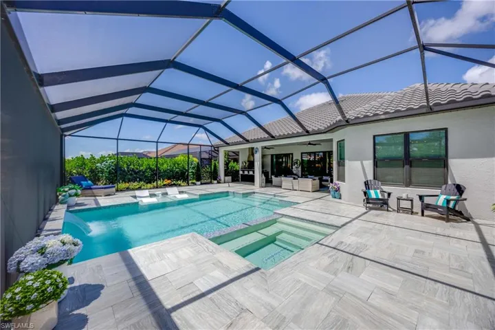 View of swimming pool featuring ceiling fan, an in ground hot tub, a lanai, and a patio area