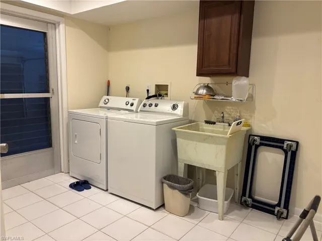 Laundry area with white tile flooring and wall-mounted cabinetry