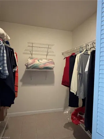 This walk-in closet features tiled flooring and wire shelving for storage