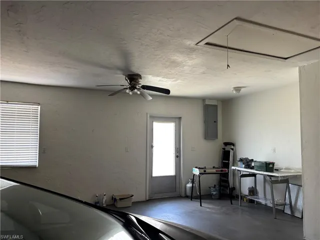 The garage features a ceiling fan, a window with blinds, and an accessible attic hatch