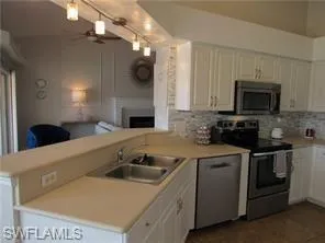 Kitchen featuring white cabinets, ceiling fan, appliances with stainless steel finishes, and kitchen peninsula