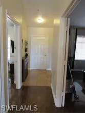 Hall with dark hardwood / wood-style floors
