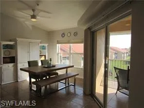 Dining space featuring lofted ceiling, ceiling fan, and dark tile patterned flooring