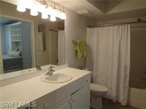 Full bathroom with shower / tub combo with curtain, vanity, and toilet